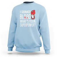 Light blue crewneck sweatshirt with front print: “I Donate Blood What’s Your Superpower?”
