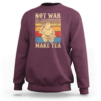 Maroon crewneck sweatshirt with Buddha graphic and 'NOT WAR MAKE TEA' text.