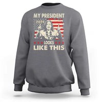 Charcoal crewneck sweatshirt with bold graphic text "MY PRESIDENT LOOKS LIKE THIS"