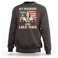 Dark chocolate crewneck sweatshirt with bold graphic text "MY PRESIDENT LOOKS LIKE THIS"