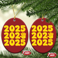 Two red round 2025 holiday ornaments with yellow “2025” and handprint icon