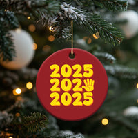 Red round 2025 holiday ornament featuring yellow “2025” text and handprint icon