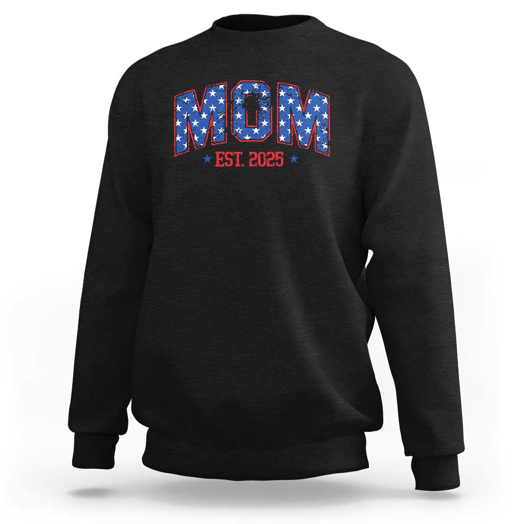 Black sweatshirt with patriotic flag "MOM" graphic and "EST. 2025" text