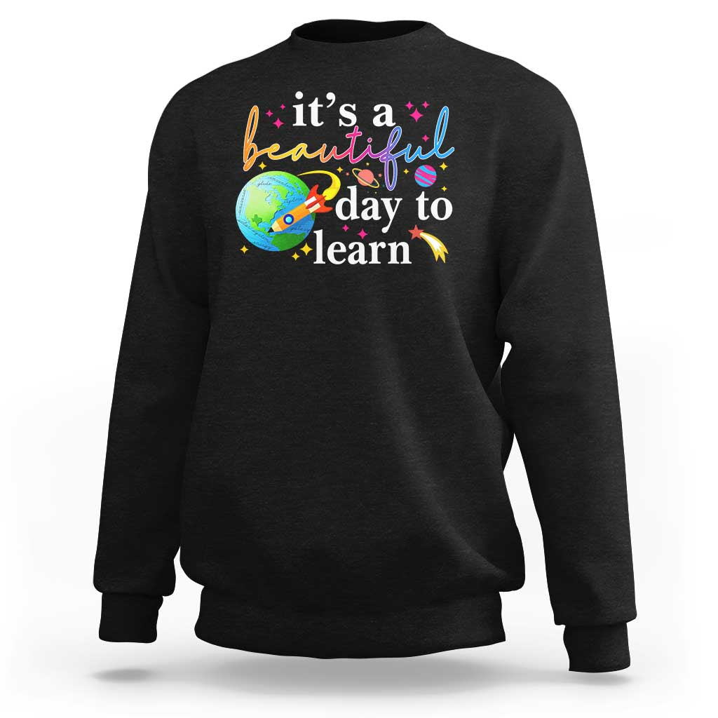 Black crewneck sweatshirt with "it's a beautiful day to learn" graphic