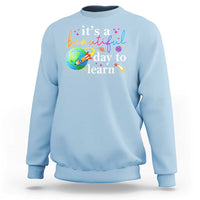 Light blue crewneck sweatshirt with "it's a beautiful day to learn" graphic