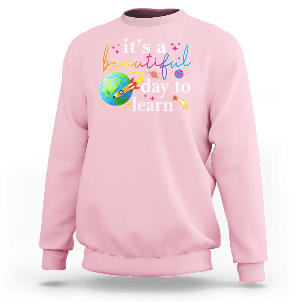 Light pink crewneck sweatshirt with "it's a beautiful day to learn" graphic