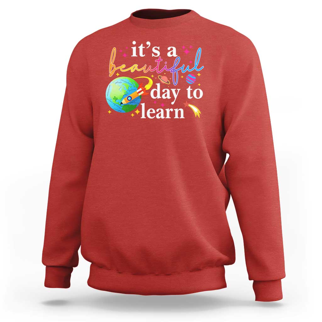 Red crewneck sweatshirt with "it's a beautiful day to learn" graphic
