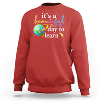 Red crewneck sweatshirt with "it's a beautiful day to learn" graphic