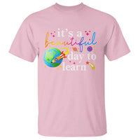 Light pink teacher T-shirt with "it's a beautiful day to learn" graphic