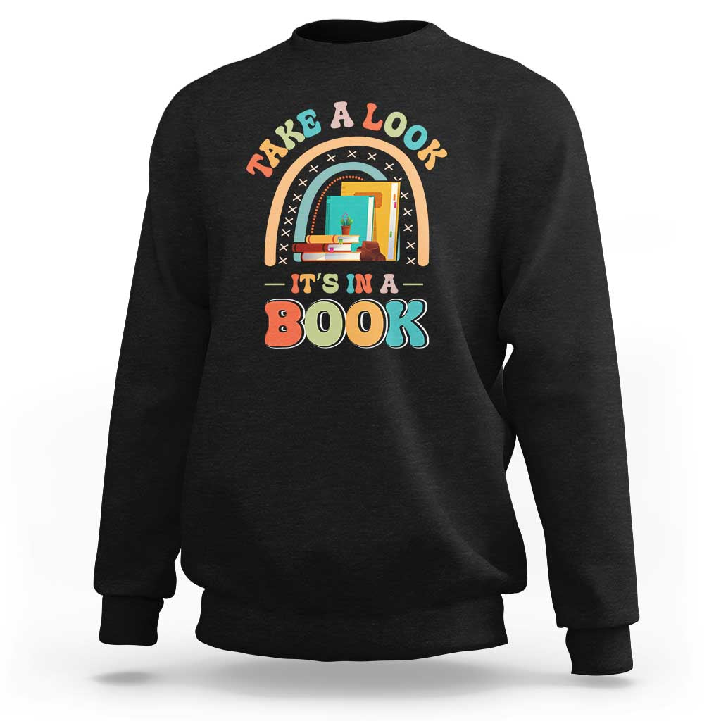 Black librarian sweatshirt with colorful “It’s in a Book” front graphic.
