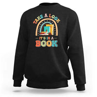 Black librarian sweatshirt with colorful “It’s in a Book” front graphic.