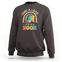 Dark brown librarian sweatshirt with colorful “It’s in a Book” front graphic.
