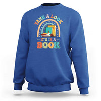Royal blue librarian sweatshirt with colorful “It’s in a Book” front graphic.