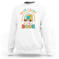 White librarian sweatshirt with colorful “It’s in a Book” front graphic.
