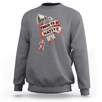 Gray crewneck sweatshirt with “PROUD TO BE NATIVE” graphic on chest