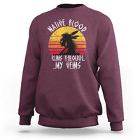 Maroon crewneck sweatshirt with long sleeves and Native graphic on chest.