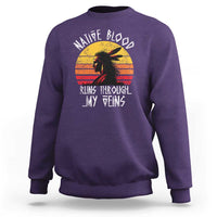 Purple crewneck sweatshirt with long sleeves and Native graphic on chest.