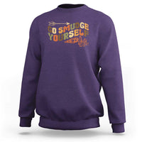 Purple crewneck sweatshirt with “Go Smudge Yourself” graphic on the chest
