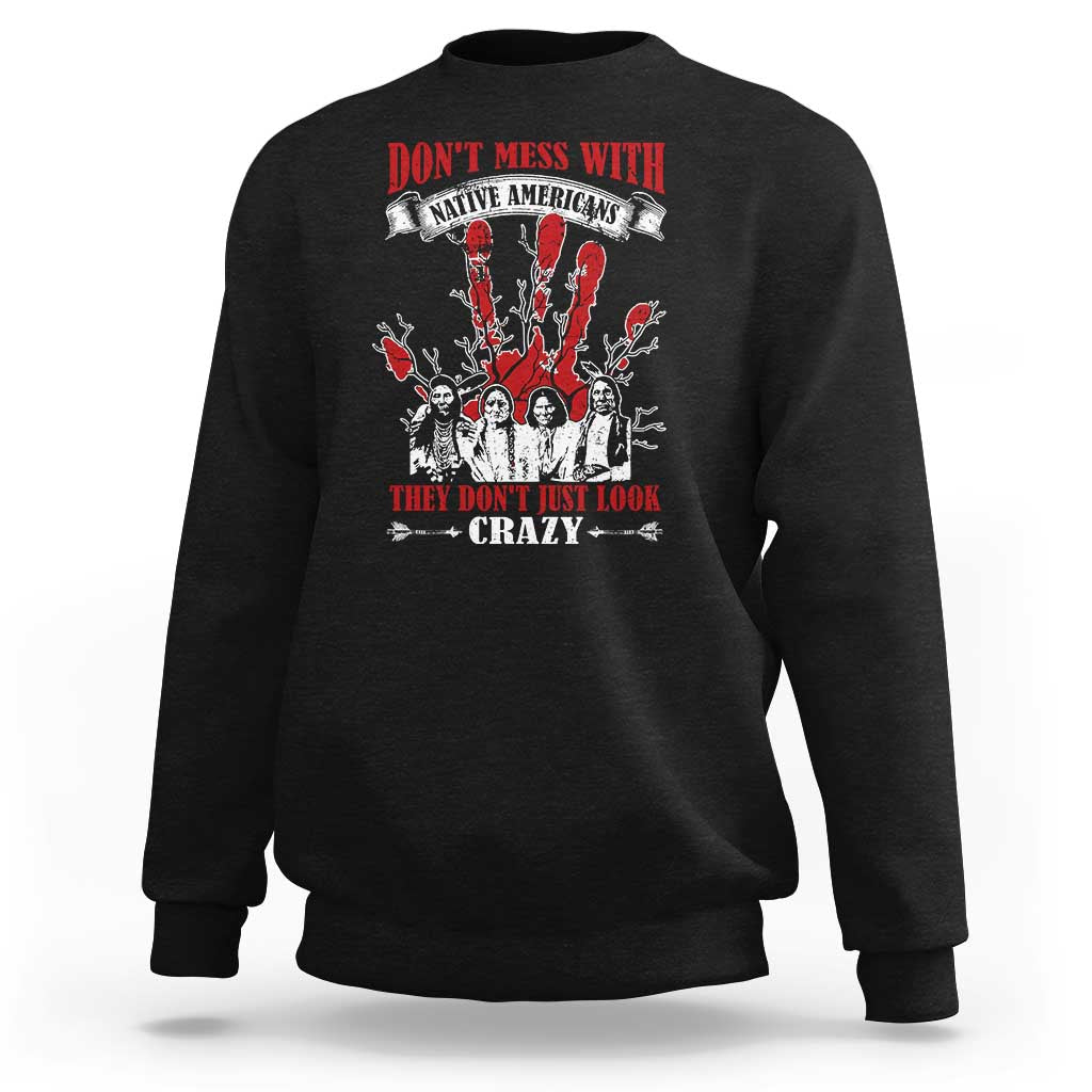 Black sweatshirt with front graphic text and Native American-style figures in red and white