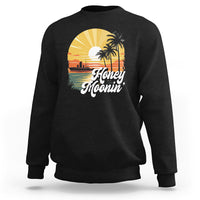 Black sweatshirt with “Honey Moonin” beach graphic and palm tree print