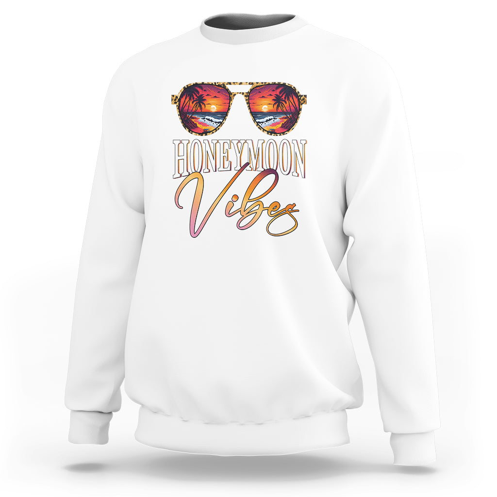 White sweatshirt with “HONEYMOON Vibes” tropical graphic print on back