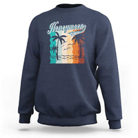 Dark navy crewneck sweatshirt with 'Honeymoon' beach graphic panel at chest