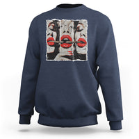 Dark blue crewneck sweatshirt with front graphic of stylized faces and red lips