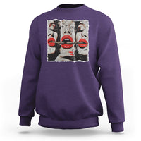 Purple crewneck sweatshirt with front graphic of stylized faces and red lips
