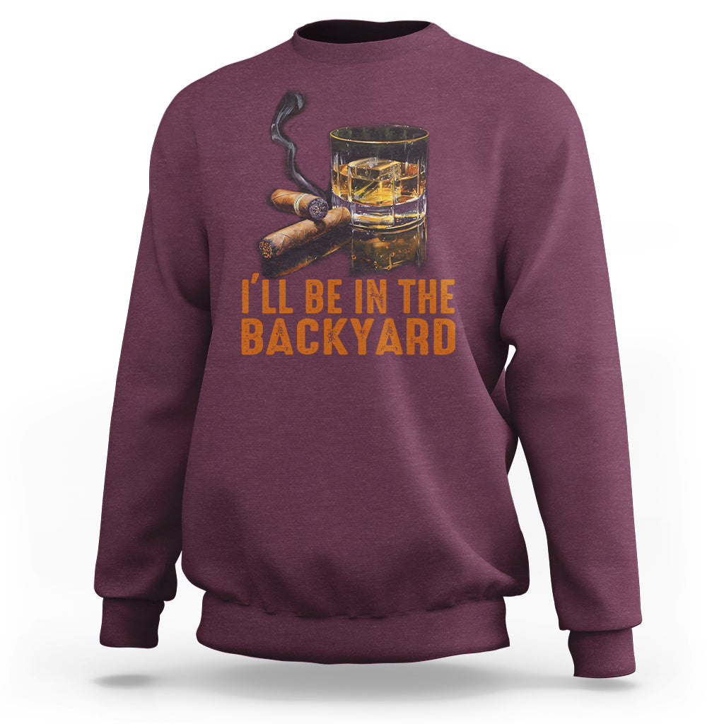 Maroon sweatshirt with whiskey glass and cigars graphic; text 'I'll be in the backyard'.