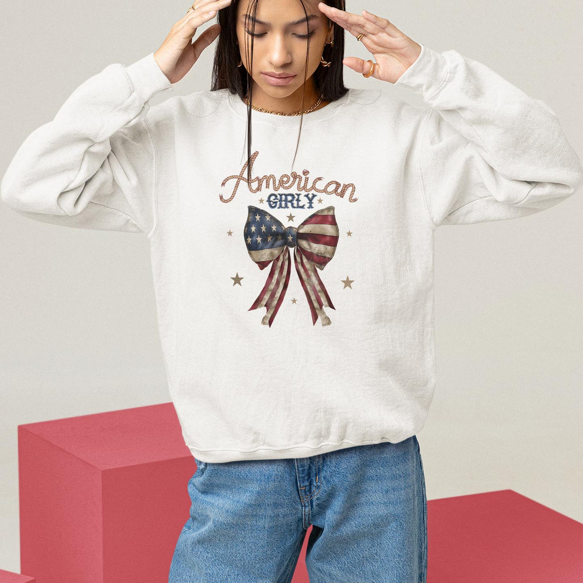 White crewneck sweatshirt with 'American Girl' and stars-and-flag bow graphic