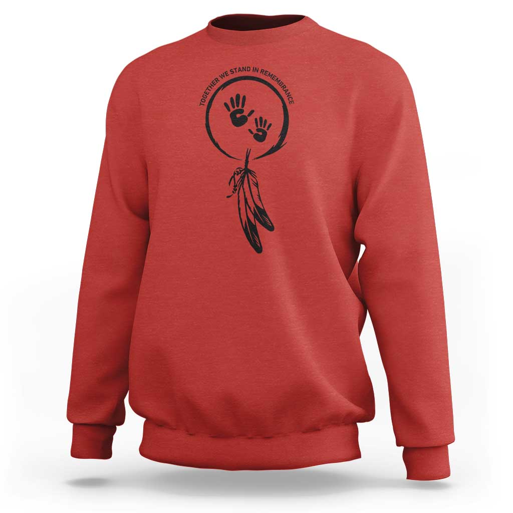 Red sweatshirt with circular hand and dreamcatcher-style graphic on chest