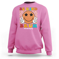 Pink crewneck sweatshirt with smiley anti-bullying graphic and "Be Kind" front print