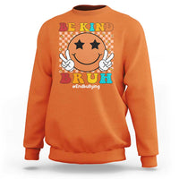 Red crewneck sweatshirt with smiley anti-bullying graphic and "Be Kind" "BrUh" text