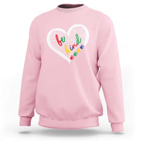Light pink sweatshirt with large white heart graphic and colorful message text art