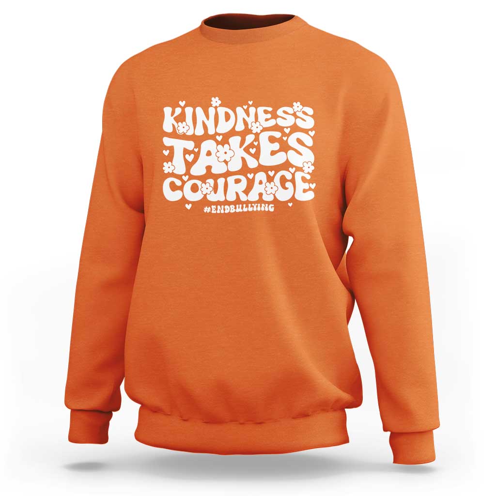 Orange crewneck sweatshirt with “Kindness Takes Courage” anti-bullying graphic