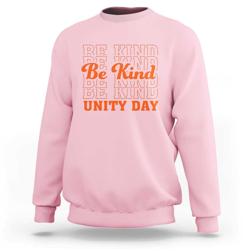 Light pink crewneck sweatshirt with “BE KIND” and “UNITY DAY” graphic text in orange and blue