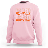 Light pink crewneck sweatshirt with “BE KIND” and “UNITY DAY” graphic text in orange and blue
