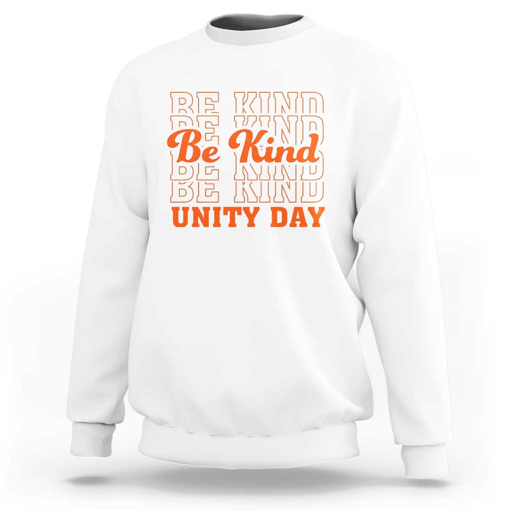 White crewneck sweatshirt with “BE KIND” and “UNITY DAY” graphic text in orange and blue