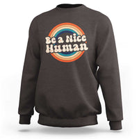 Charcoal crewneck sweatshirt with 'Be a Nice Human' rainbow graphic