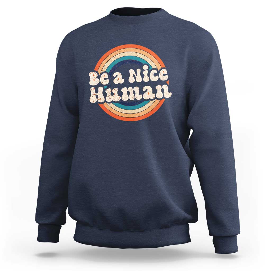 Navy crewneck sweatshirt with 'Be a Nice Human' rainbow graphic