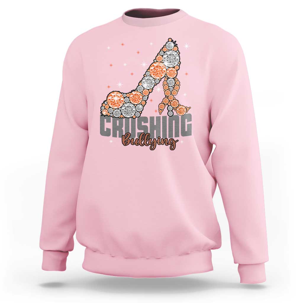 Light pink sweatshirt with “Crushing Bullying” graphic and orange dotted ribbon