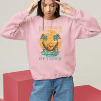 Women's light pink sweatshirt with “THIS CHICK IS RETIRED” palm graphic, long sleeves