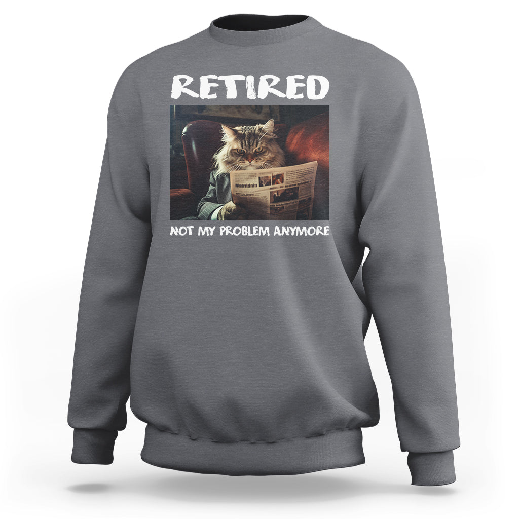 Charcoal crewneck sweatshirt with 'Retired' cat newspaper graphic, 'Not My Problem Anymore'.
