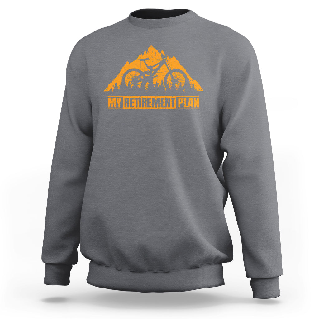 Charcoal crewneck sweatshirt with orange bicycle retirement plan graphic