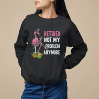 Black crewneck retirement sweatshirt with pink flamingo graphic and “Retired / Not My / Problem / Anymore” text.