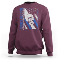 Maroon crewneck sweatshirt with blue graphic of two fists and stars on the chest.