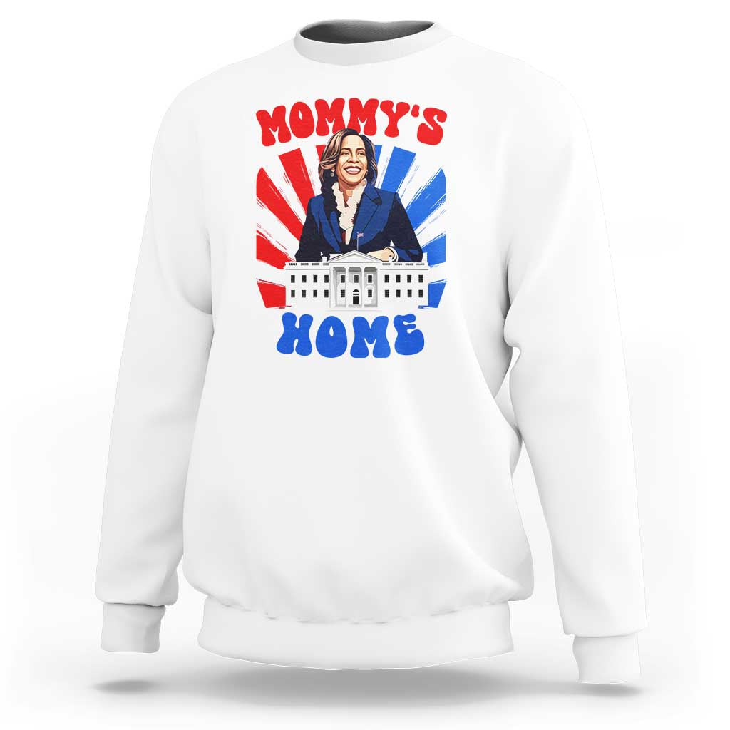 White crewneck sweatshirt with “MOMMY’S HOME” graphic featuring a woman and building.