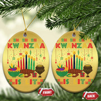 Two gold oval Kwanzaa ornaments with “Kwanzaa” text and candle design, hanging loops
