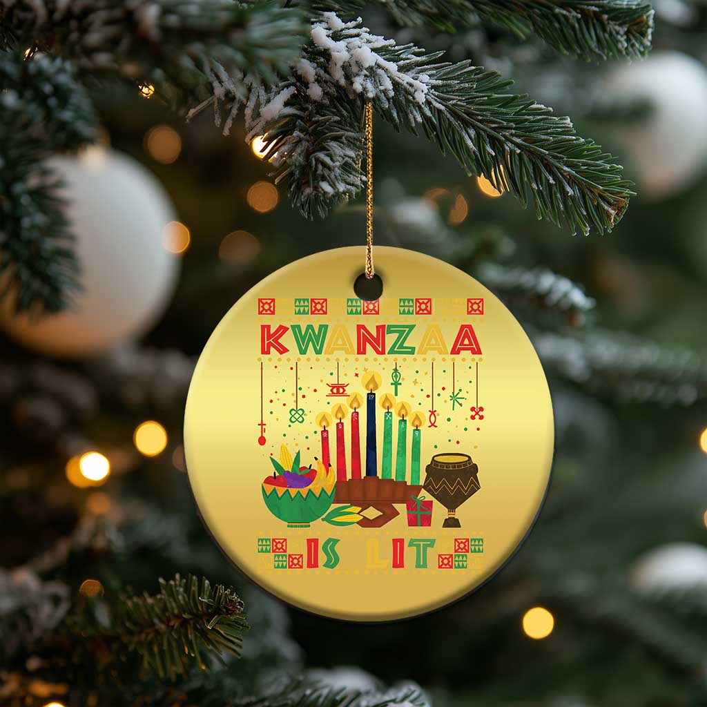 Gold round Kwanzaa ornament hanging from evergreen branches, with candles and “Kwanzaa”