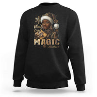 Black crewneck sweatshirt with front holiday graphic and gold "MAGIC" lettering
